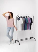 Mujer usando blusa color lila con vaias blusas colgadas.