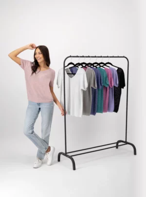 Mujer usando blusa color lila con vaias blusas colgadas.