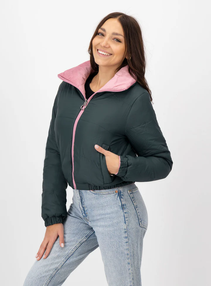 Mujer sonriendo usando chamarra color gris oscuro con rosa.